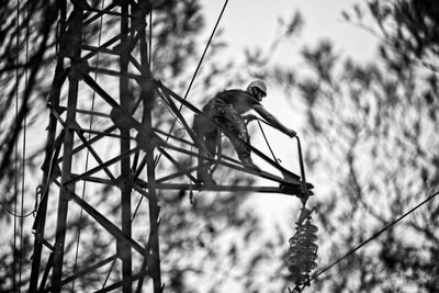 男子爬上金属梯子的灰度照片
